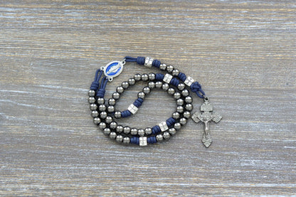 Solemn Crusader Rosary: Navy blue paracord with silver crusader Our Father beads, gunmetal Hail Mary beads, and blue enamel Miraculous Medal centerpiece.