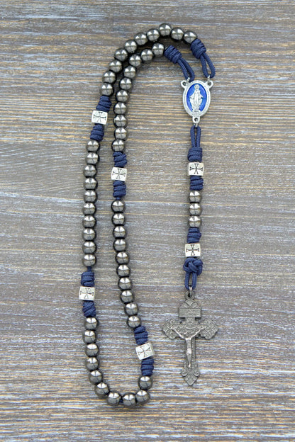 Metal paracord rosary, The Solemn Crusader, features navy blue 275 paracord, silver crusader beads, and a blue enamel Miraculous Medal centerpiece.