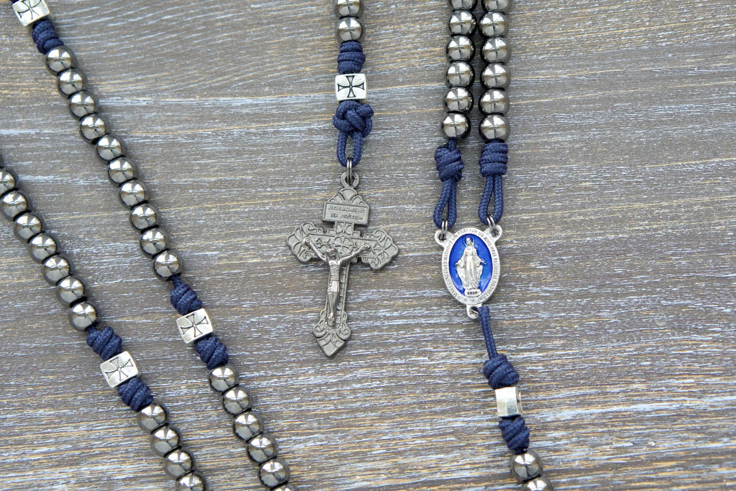 Navy blue paracord and silver crusader bead rosary, featuring a gunmetal crucifix and blue enamel Miraculous Medal centerpiece.  The Solemn Crusader rosary.