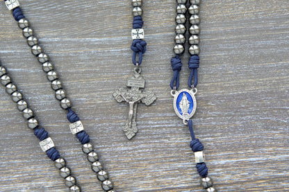 Navy blue paracord and silver crusader bead rosary, featuring a gunmetal crucifix and blue enamel Miraculous Medal centerpiece.  The Solemn Crusader rosary.