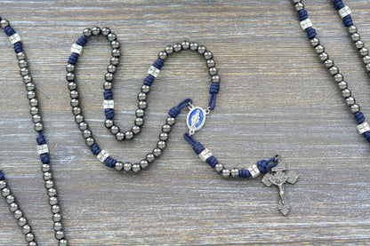 Metal paracord rosary, The Solemn Crusader, features navy blue paracord, silver crusader Our Father beads, gunmetal Hail Mary beads, and a blue enamel Miraculous Medal centerpiece.