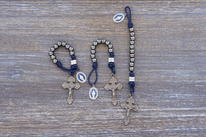 Solemn Crusader paracord rosary with silver beads, blue enamel Miraculous Medal, and gunmetal Hail Mary beads—durable, spiritual, and ready for battle.