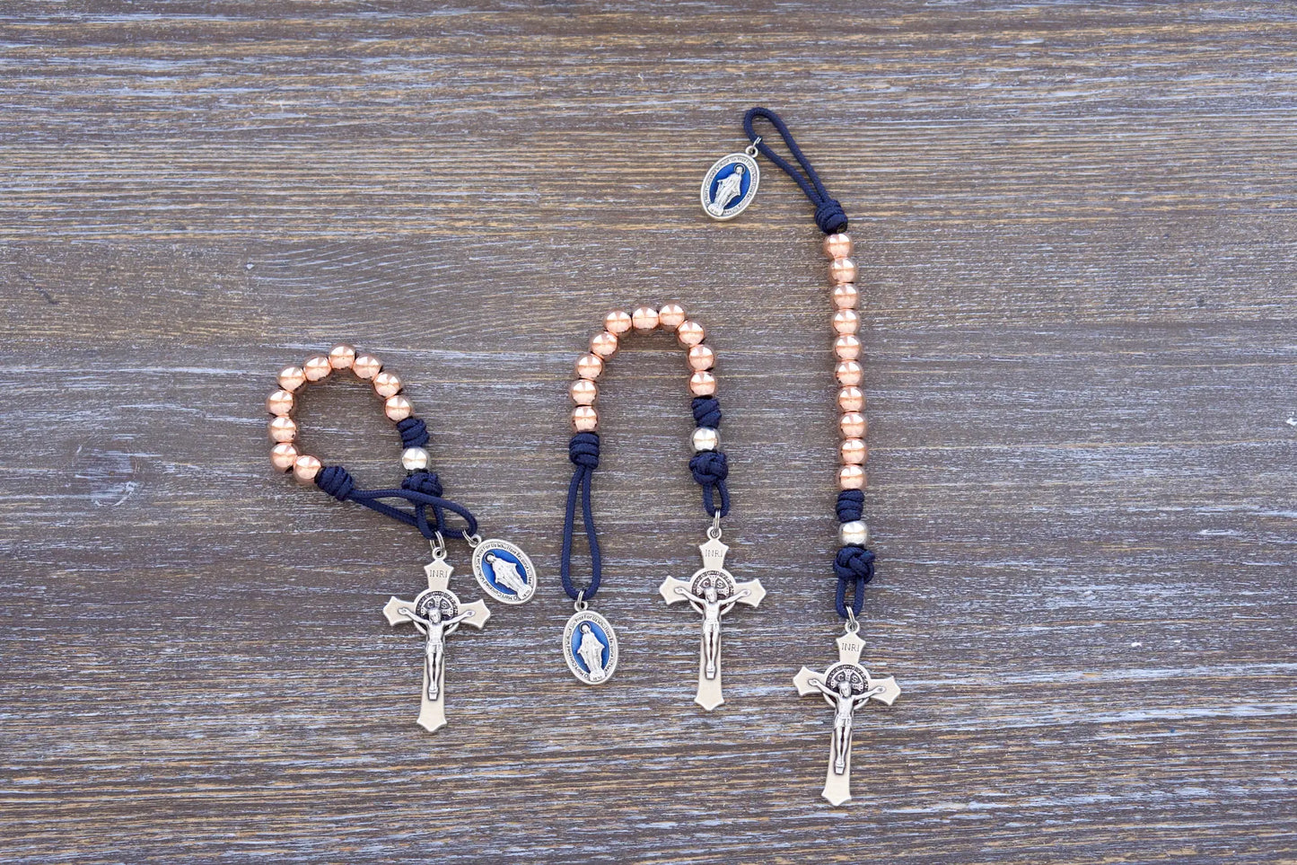 Premium metal pocket paracord rosary with rose gold metal alloy beads, benedict crucifix and blue enamel miraculous medal.