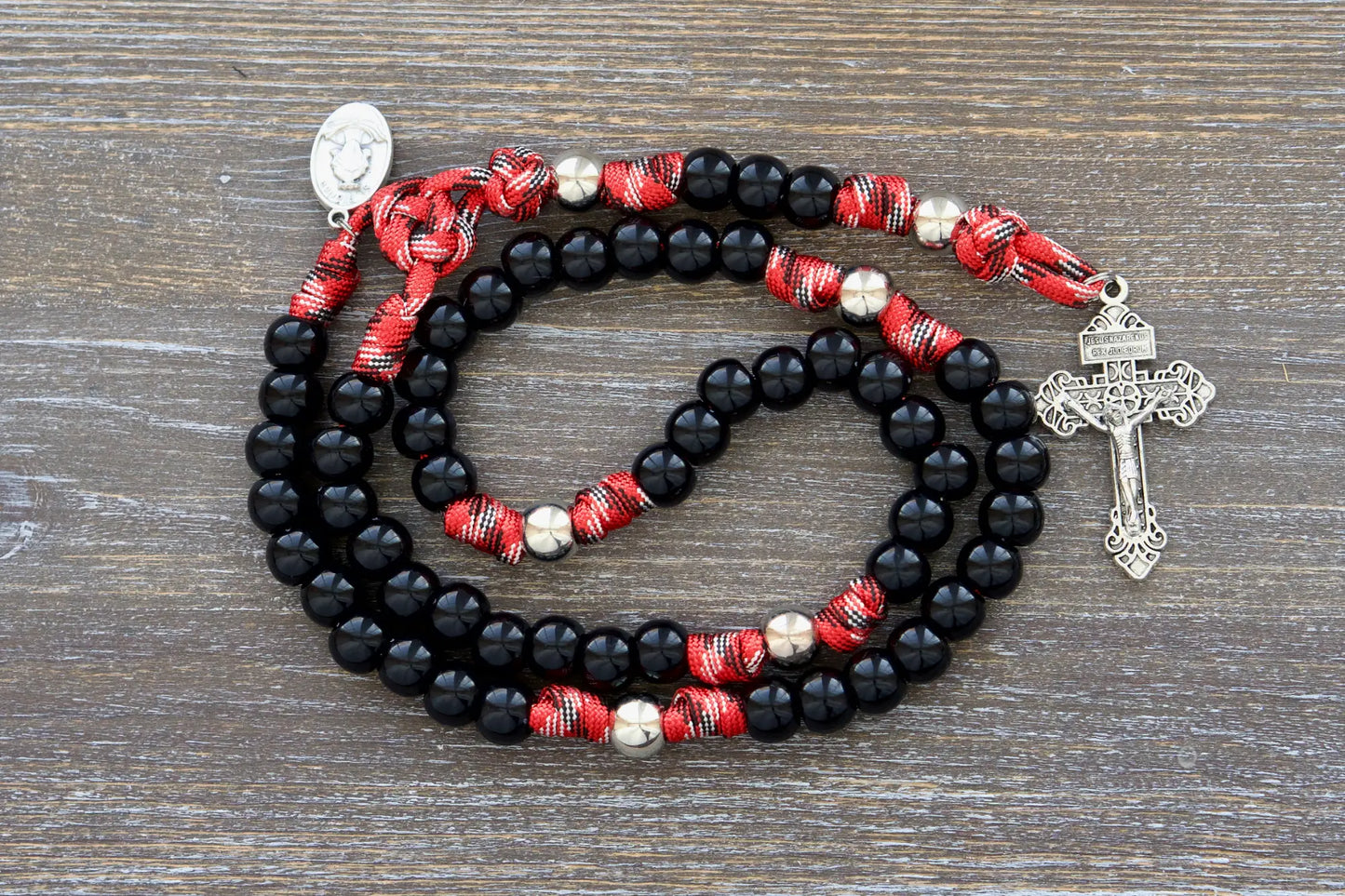 Silver and black paracord rosary, signifying strength and faith for emergency service professionals.