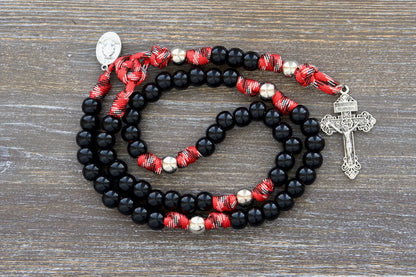 Silver and black paracord rosary, signifying strength and faith for emergency service professionals.