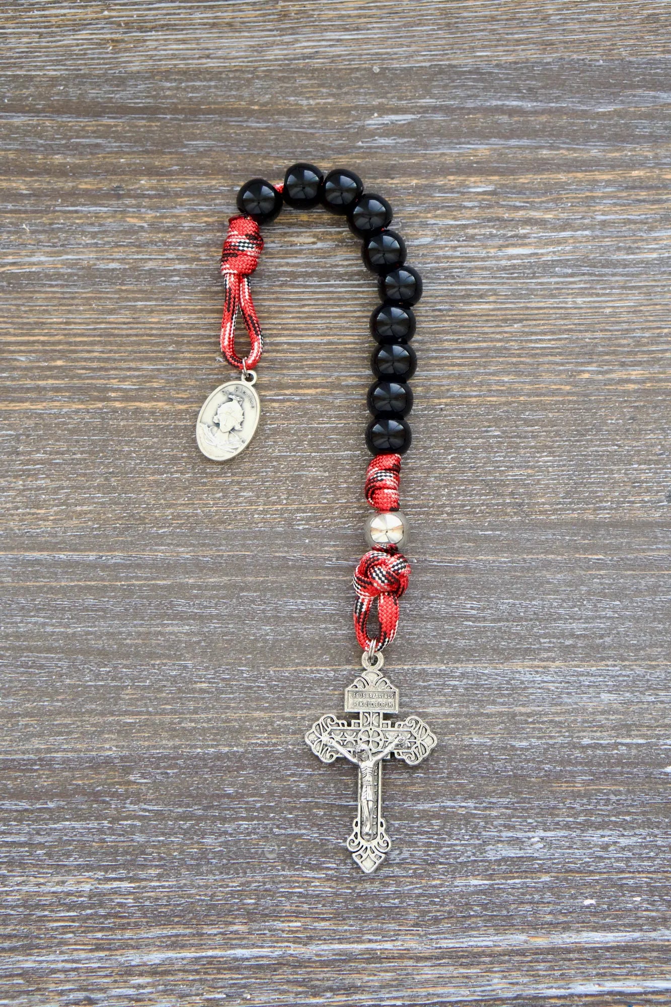 Durable paracord rosary, adorned with a silver St. Florian medal, offering spiritual support to first responders.