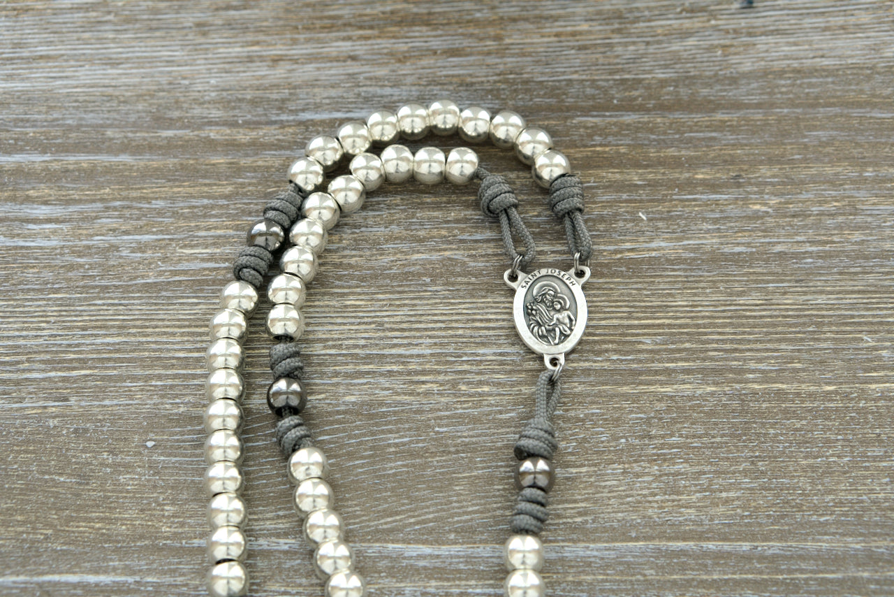 Unveil the Protector of Holy Church - St. Joseph - Premium Paracord Rosary, a symbol of strength and devotion designed for traditional Catholics. Crafted with durable grey paracord and all-silver alloy metal beads, this rosary is perfect for daily prayers.