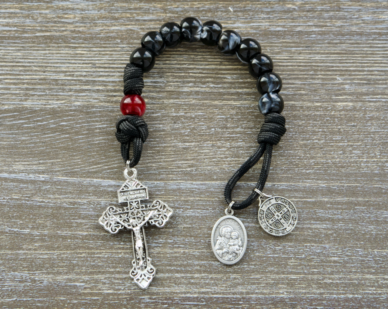 Discover the ultimate weapon against evil with our new "Terror of Demons" St. Joseph - Black and Red - 1 Decade Paracord Rosary! This durable paracord rosary is the perfect Catholic gift.