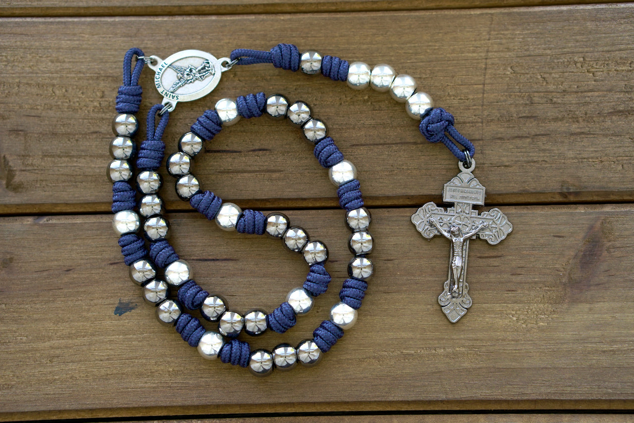 St. Michael Chaplet, blue and gunmetal paracord with 10mm alloy metal beads, featuring a silver St. Michael medal centerpiece and a Pardon crucifix. Handmade by a Catholic family for daily prayer and protection.