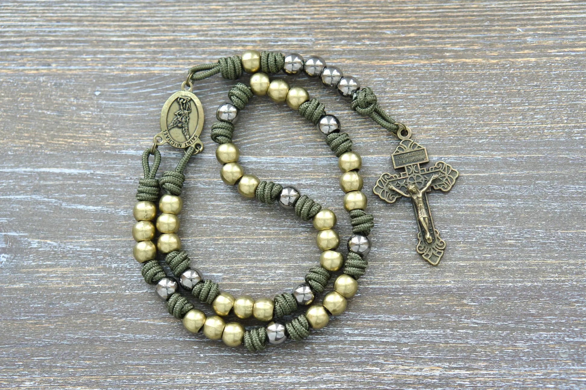St. Michael chaplet featuring green paracord, 10mm olive metal beads, and a St. Michael medal centerpiece and pardon crucifix