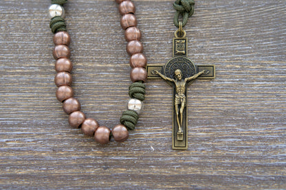 St. Michael's Shield Premium Metal Paracord Rosary: A close-up image showcasing vibrant green paracord interwoven with copper Hail Mary beads and silver Our Father beads, accented by a radiant olive St. Michael centerpiece medal and a 2.5 inch olive St. Benedict crucifix.