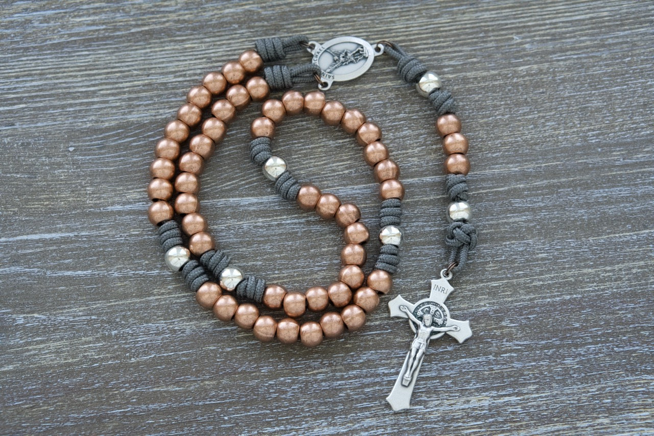 "St. Michael's Sword" Premium Paracord Rosary with Copper and Silver Beads, featuring a silver St. Michael centerpiece medal and a 2" St. Benedict crucifix for spiritual protection and unwavering faith. Handcrafted by a small Catholic family of 6 with attention to detail and durability in mind, perfect for the Church Militant's battles.