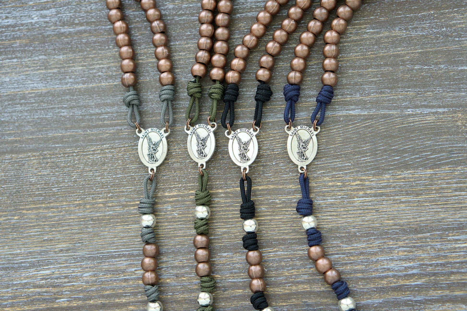 St. Michael's Sword Premium Metal Paracord Rosary: A handcrafted rosary featuring durable 275 paracord in grey, black, green, or navy blue with copper Hail Mary beads and silver Our Father beads.