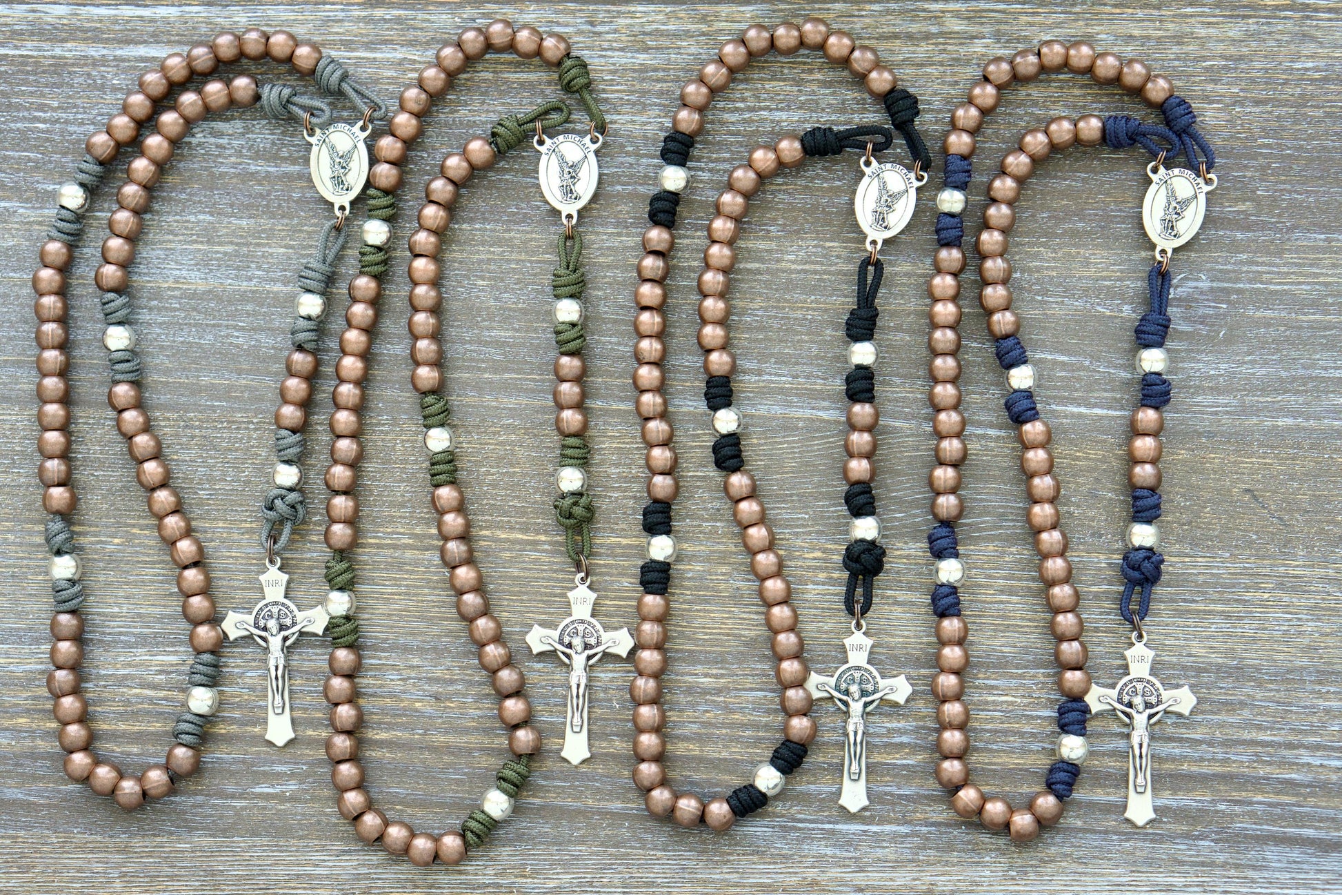 Premium paracord rosary with durable 10mm alloy metal Hail Mary (copper) and Our Father (silver) beads, featuring a radiant St. Michael centerpiece.