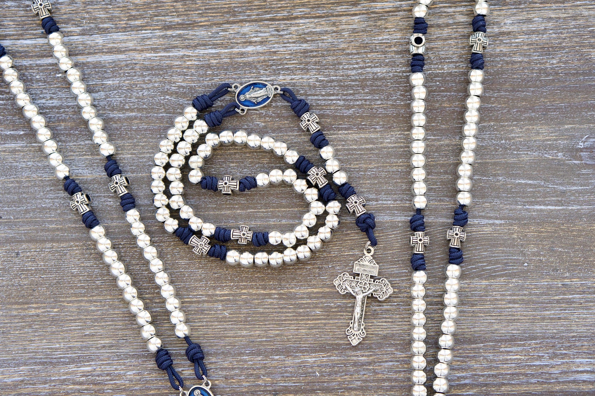 Premium navy blue paracord rosary with shimmering silver metal Hail Mary beads, an enamel Miraculous Medal centerpiece, and a silver Pardon crucifix. Handmade rosary inspired by Our Lady, Star of the Sea, for spiritual guidance and devotion.