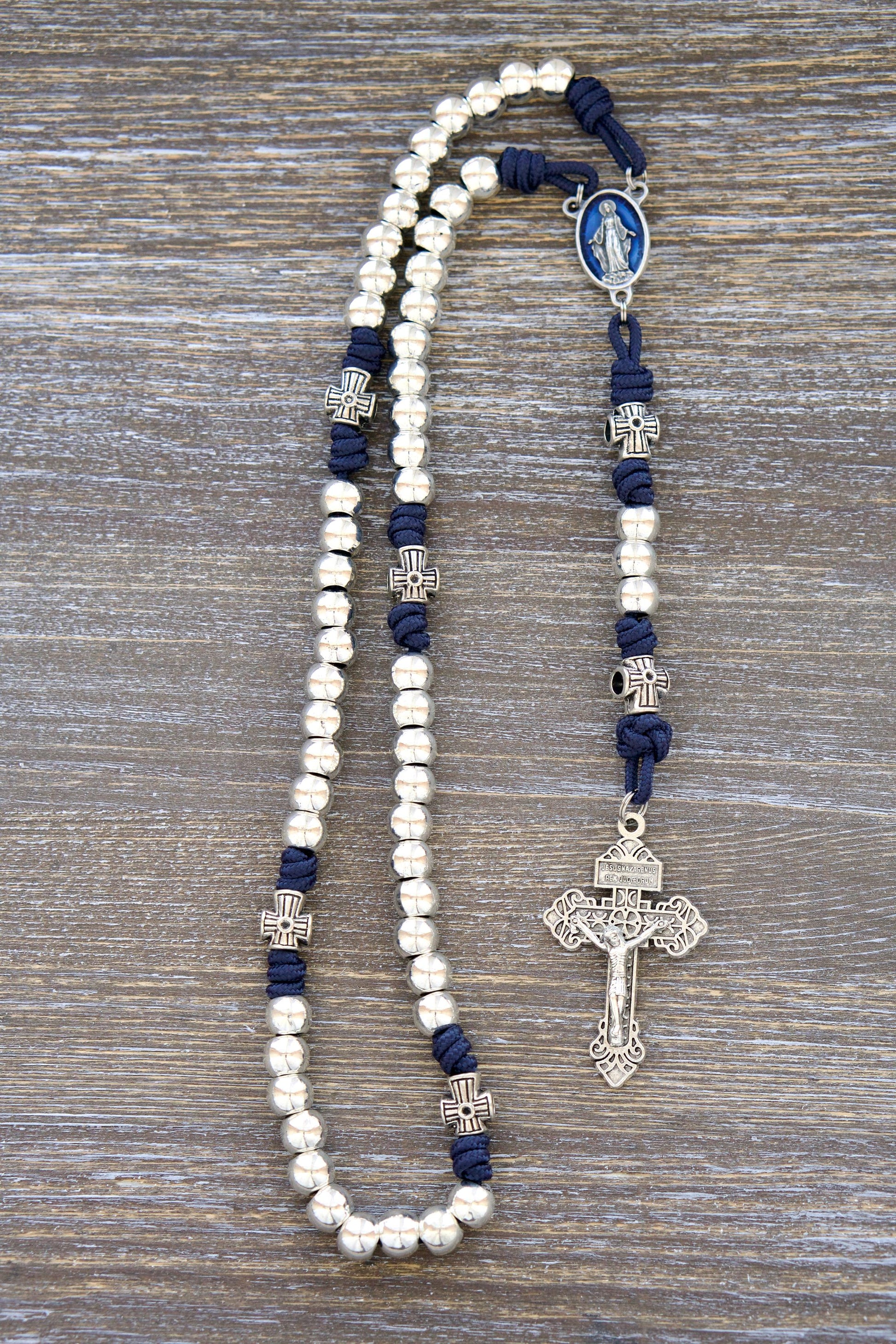 Premium Stella Maris Rosary featuring navy blue paracord, shiny silver metal Hail Mary beads, a blue enamel Miraculous Medal centerpiece, and a matching silver Pardon Crucifix. Handmade with high quality materials for a durable and beautiful devotional tool.