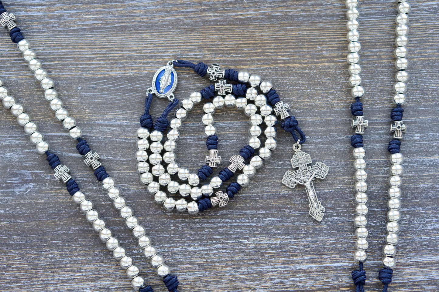 Navy blue paracord Stella Maris rosary with shiny silver metal alloy Hail Mary and cross-shaped Our Father beads, featuring a blue enamel Miraculous Medal and silver Pardon crucifix.