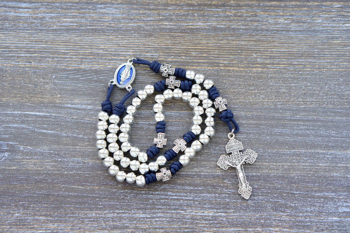 Navy blue paracord "Stella Maris" rosary with shiny silver metal Hail Mary beads, cross-shaped Our Father beads, and a blue enamel Miraculous Medal centerpiece.