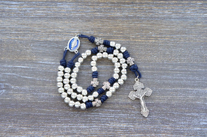 Navy blue paracord "Stella Maris" rosary with shiny silver metal Hail Mary beads, cross-shaped Our Father beads, and a blue enamel Miraculous Medal centerpiece.