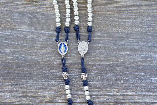 Navy blue paracord Stella Maris Rosary featuring silver metal Hail Mary beads, a blue enamel Miraculous Medal centerpiece, and a silver Pardon crucifix.
