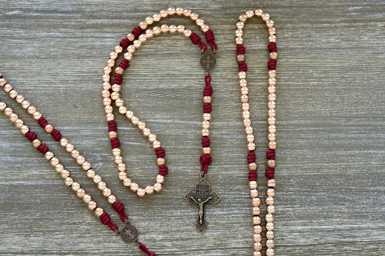 Beautifully crafted Strength & Virtue Maroon, Rosegold, Copper Premium Metal Paracord Rosary with durable unbreakable paracord and high quality metal alloy beads. Featuring a copper St. Benedict Centerpiece for protection and guidance.