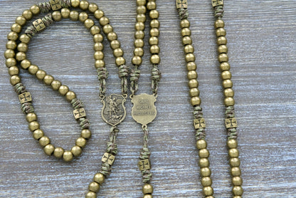 The Strength of the Militant Holy Rosary, a Premium Metal Paracord Rosary with olive green camo paracord, featuring durable alloy metal Crusader beads and a St. Michael centerpiece medal, perfect for Catholics seeking spiritual strength in their ongoing battle against evil.