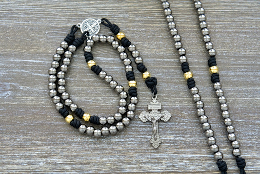 Stronghold of Grace paracord rosary with gunmetal Hail Mary beads, gold Our Father beads, St. Benedict medal, and 2-inch Pardon crucifix.
