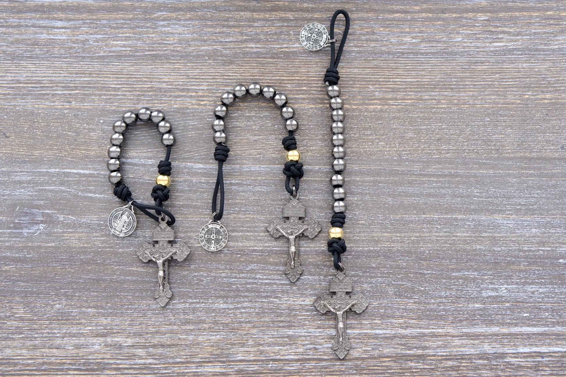 Stronghold of Grace paracord rosary with 10mm gunmetal beads, gold Our Father beads, and 2-inch Pardon crucifix