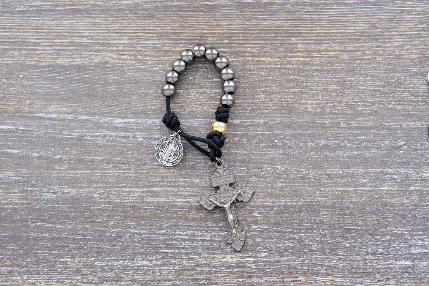 Stronghold of pocket Grace paracord rosary with 10mm gunmetal Hail Mary beads, gold Our Father beads, and 2-inch Pardon crucifix