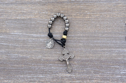 Stronghold of pocket Grace paracord rosary with 10mm gunmetal Hail Mary beads, gold Our Father beads, and 2-inch Pardon crucifix