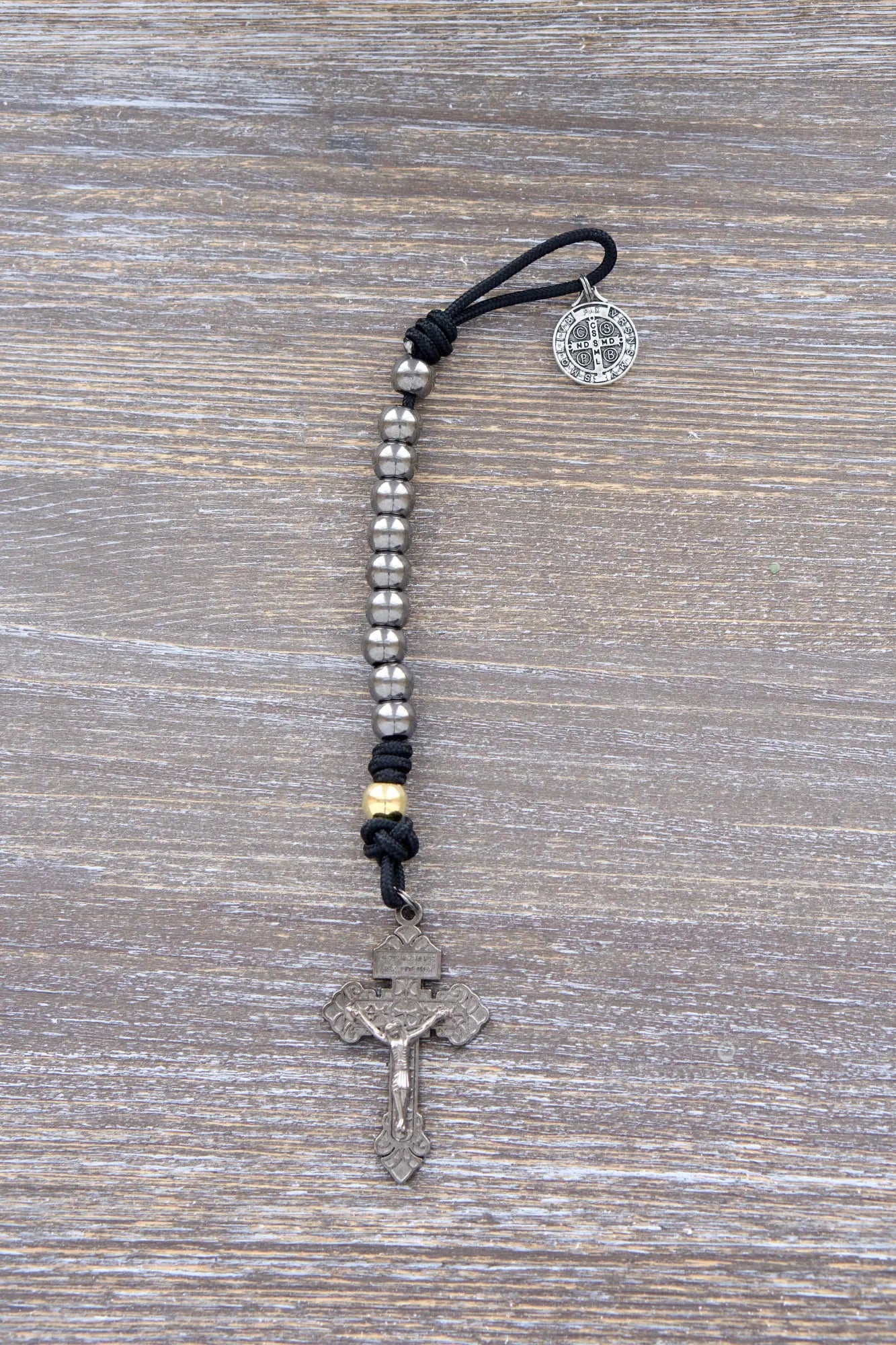Stronghold of Grace paracord rosary shines with gunmetal & gold beads, bold Pardon crucifix — a warrior's faith tool for every prayer!