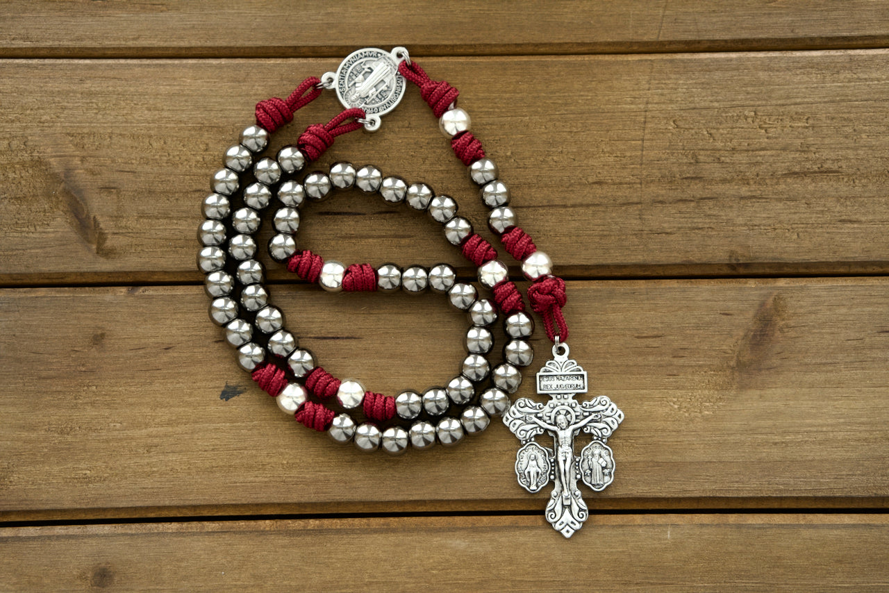 Maroon, Gunmetal and Silver Premium Paracord Rosary featuring a powerful St. Benedict medal centerpiece, silver Our Father beads, gunmetal Hail Mary beads, and a 2" Pardon Crucifix for unyielding devotion.