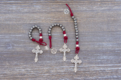 Sword of the Faithful pocket paracord rosary with gunmetal beads, silver Our Father beads, St. Benedict medal, and 2-inch Pardon crucifix.