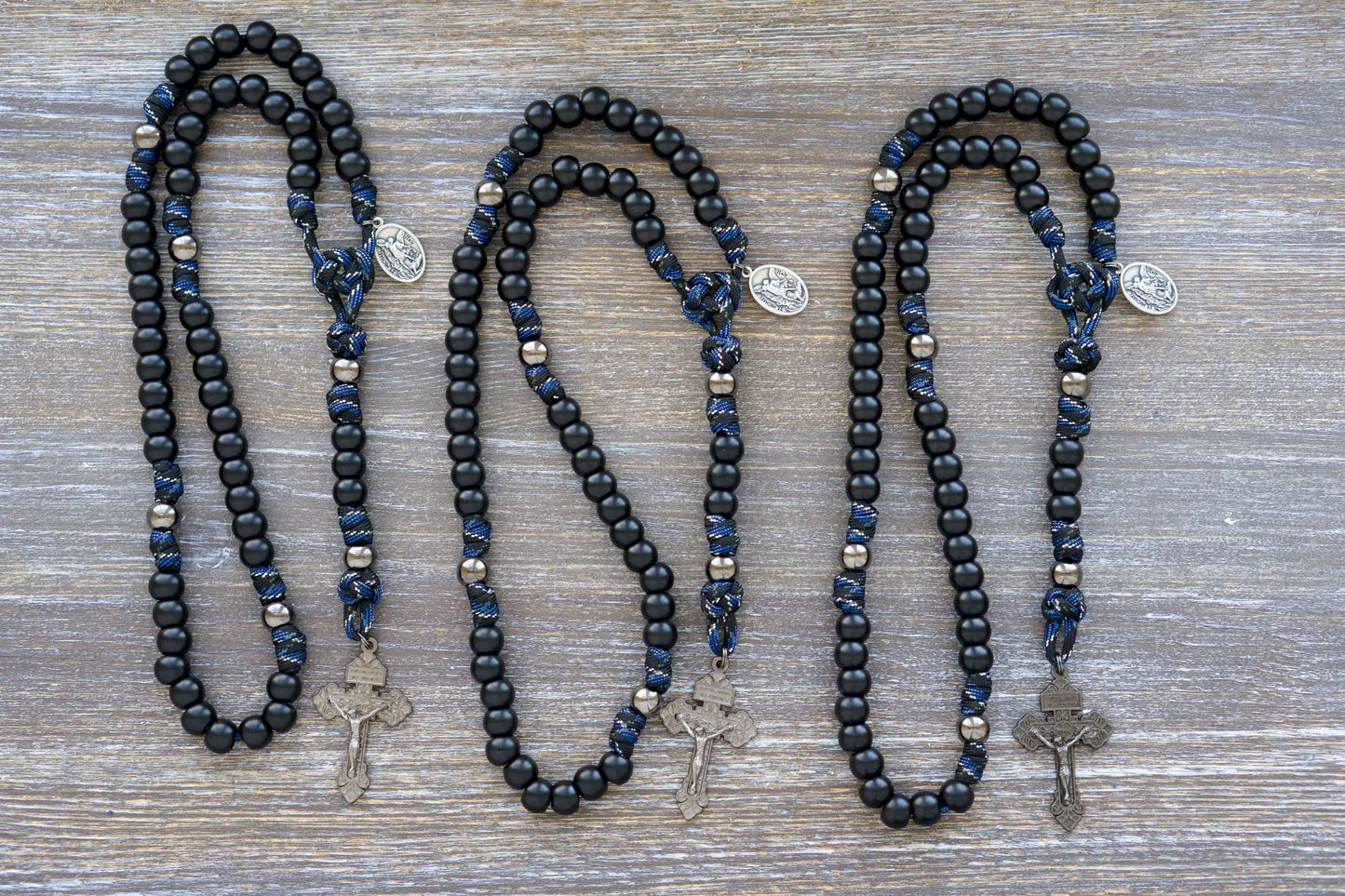 Thin Blue Line - 5 Decade Paracord Rosary: Camo paracord, matte black Hail Mary beads, gunmetal Our Father beads, and a devotional medal featuring St. Michael and a Guardian Angel. 