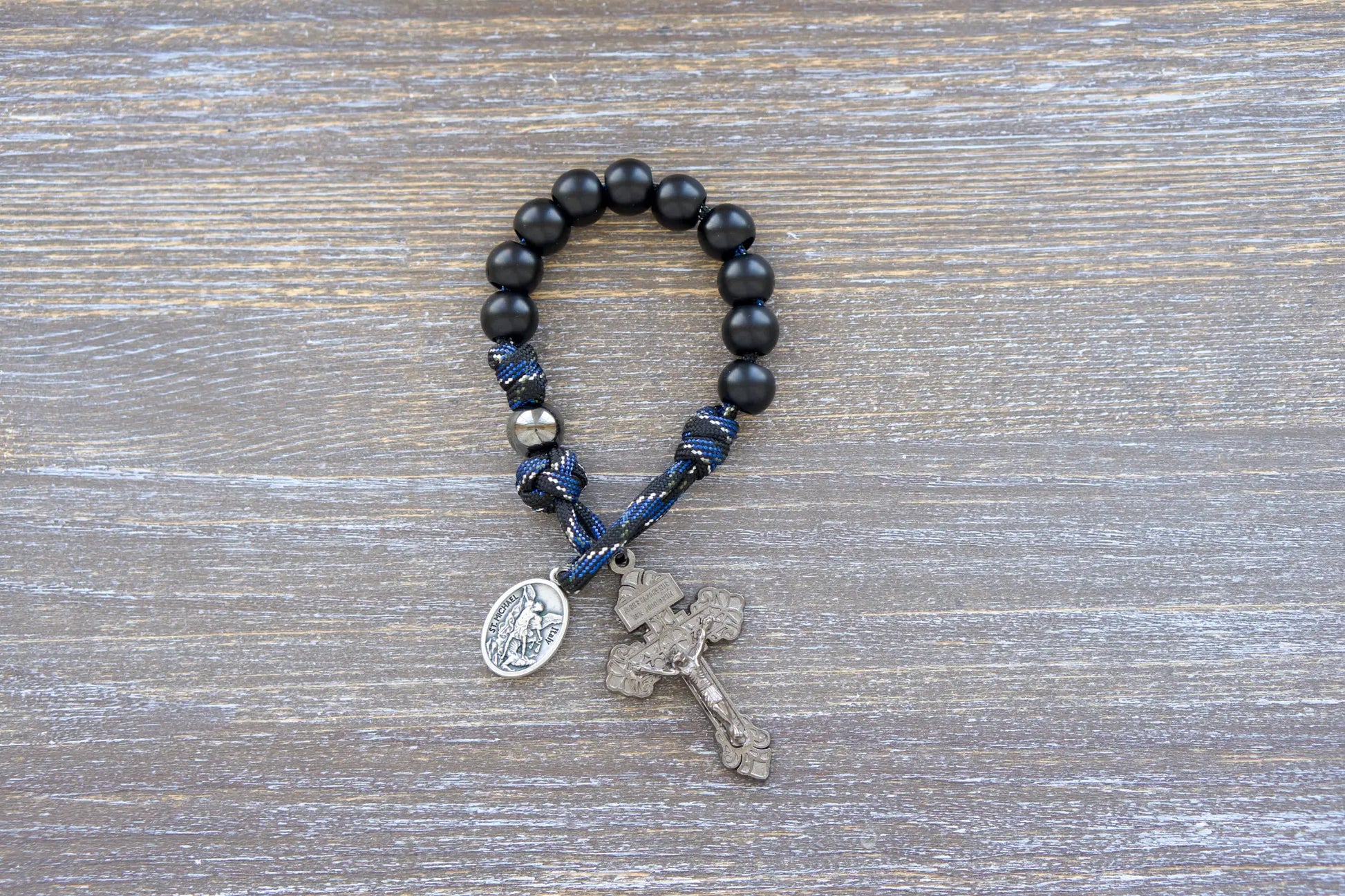 Thin Blue Line Pocket Rosary: Black and blue camo paracord with gunmetal & matte black acrylic beads, featuring a St. Michael medal and gunmetal crucifix.