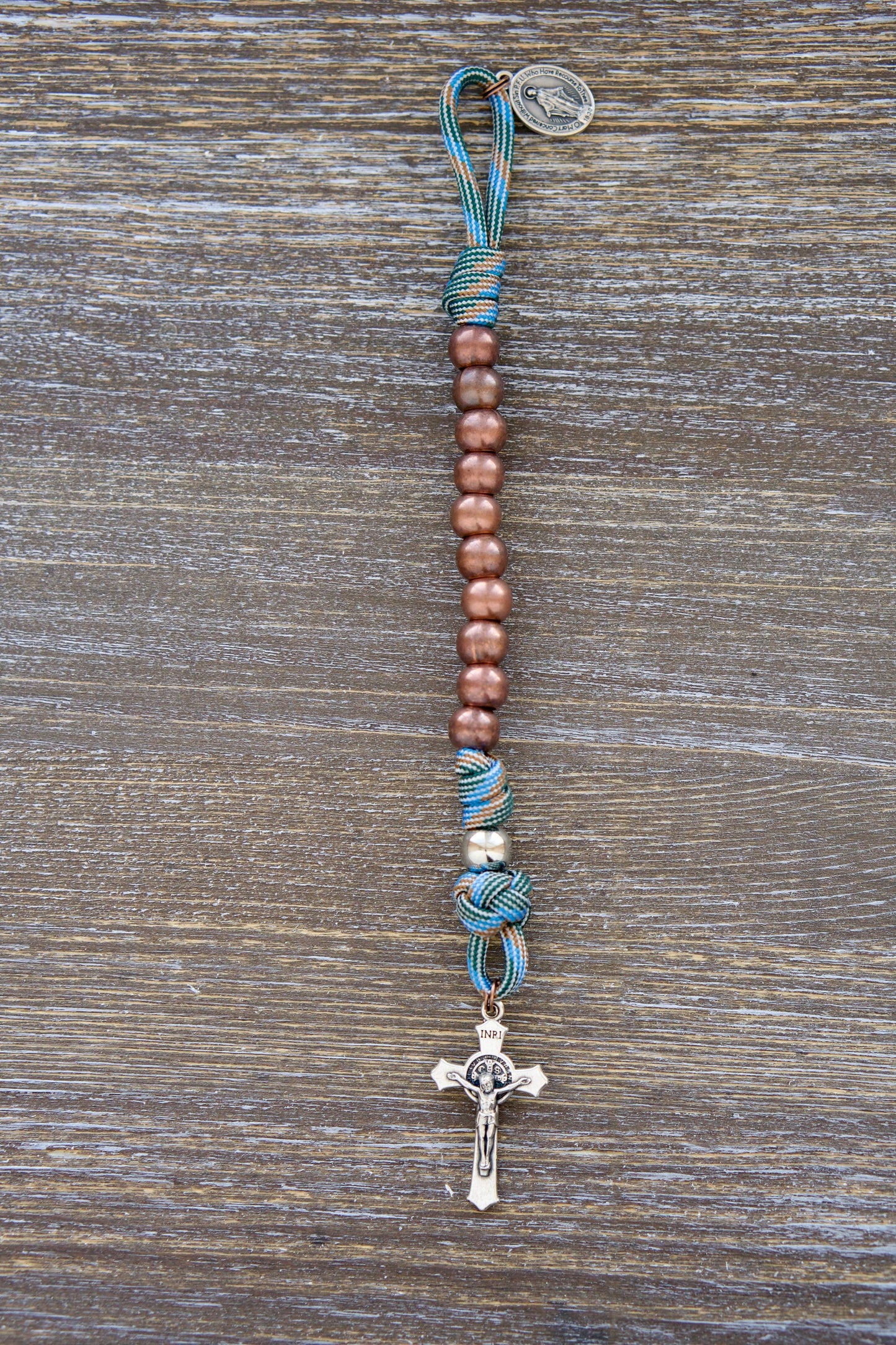 Bright light blue and copper paracord rosary with acrylic beads and Miraculous Medal, styled for young boys' Catholic adventures.