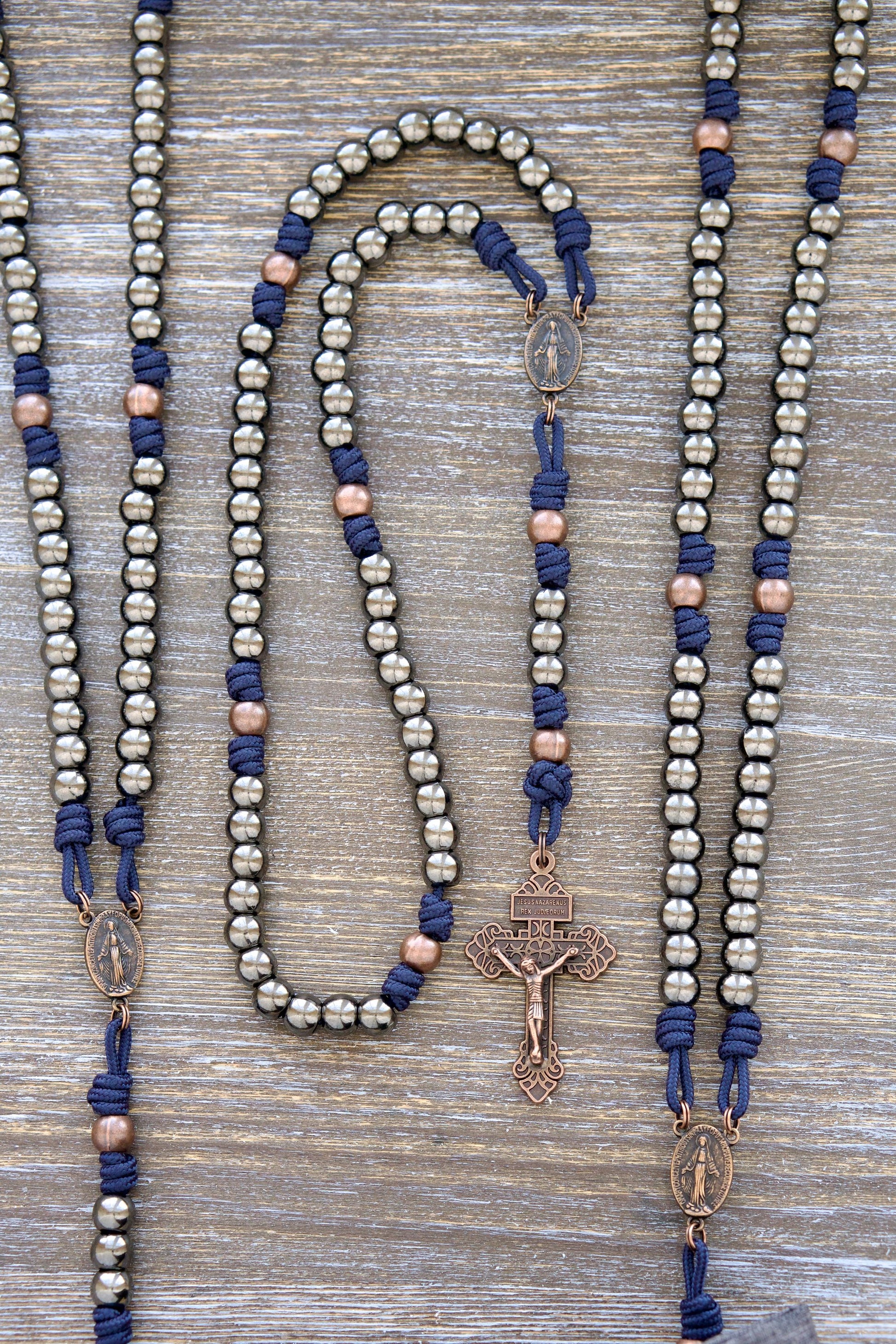 Unbreakable Fidelity Premium Metal Paracord Rosary - Handmade Navy Blue paracord with 10mm gunmetal Hail Mary beads, antique copper Our Father beads, copper Miraculous Medal centerpiece, and a copper Pardon Crucifix.