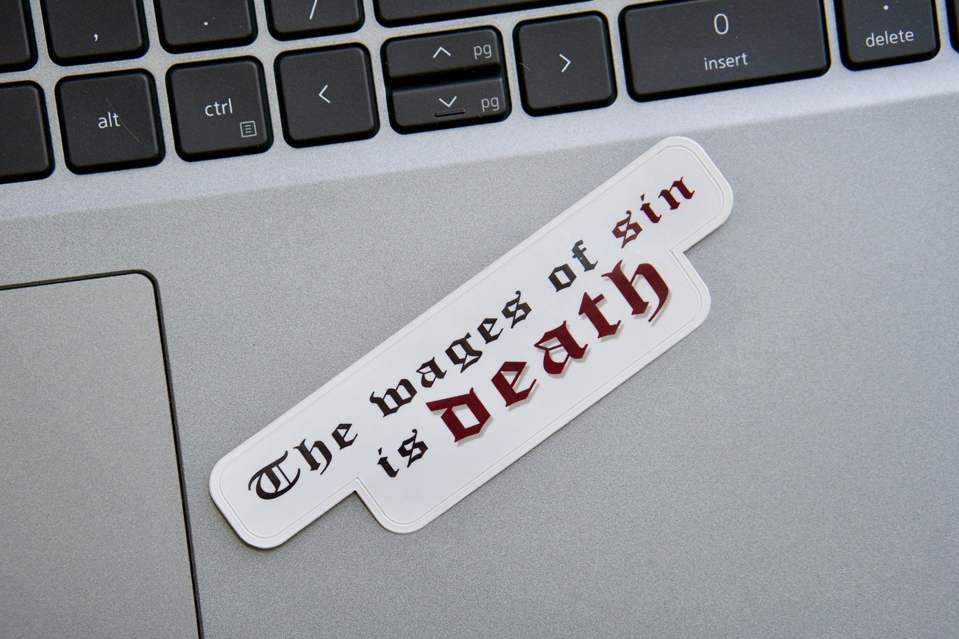 Wages of Sin Vinyl Sticker - A powerful reminder of the consequences of sin and the importance of seeking God's grace, perfect for laptops, water bottles, or as a thoughtful Catholic gift. Size: 4" x 1".