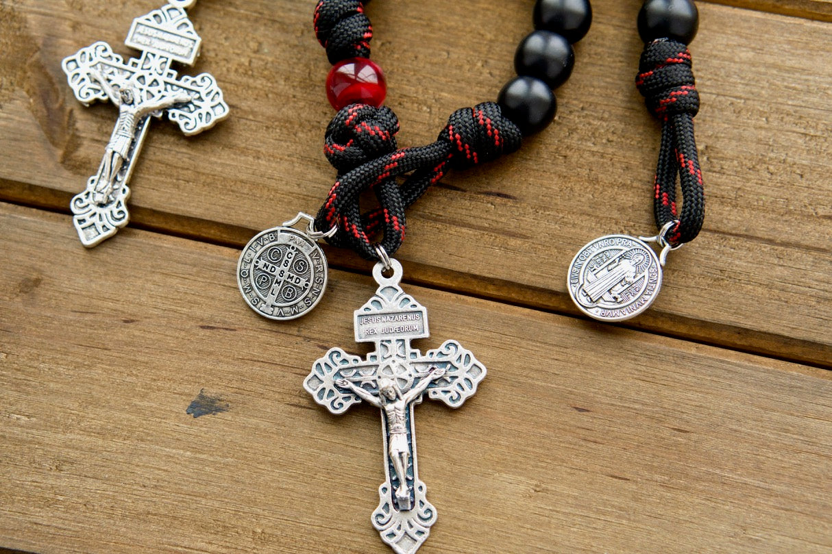 The Blood of Christ - 1 Decade Paracord Rosary, a powerful symbol of faith and devotion handcrafted by our Catholic family. This unbreakable paracord rosary features a silver pardon crucifix, St. Benedict medal, and red and black beads for daily prayer and spiritual strength.