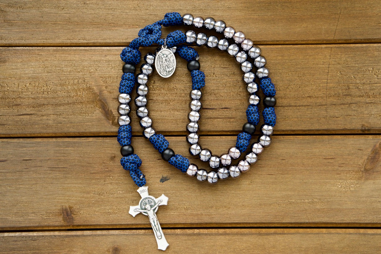 Empower your little warrior with the Kids Blue and Gunmetal - 5 Decade Paracord Rosary. This durable, premium, unbreakable paracord rosary features a blue rope with gunmetal colored beads and a St. Michael & Guardian Angel devotional medal, perfect for young Catholics ready to fight the good fight!