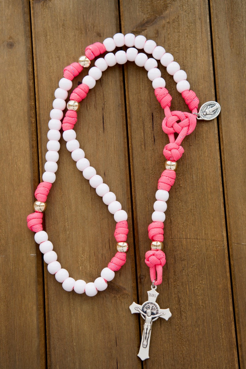 Kid's pink paracord rosary with white Hail Mary beads, rose gold Our Father beads, St. Benedict crucifix, and Miraculous Medal. Perfect for First Communion or Easter gifts. Durable, functional, and a great Catholic gift for any occasion.