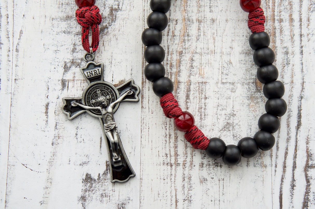 The "Crimson Shield Holy Spirit Confirmation - 5 Decade Paracord Rosary" stands as a testament to strength and resilience in faith. This premium paracord rosary is crafted with sturdy 550 paracord in deep maroon red, accompanied by dark maroon Our Father beads and matte black Hail Mary beads. The 3" St. Benedict crucifix, adorned with black enamel, adds a touch of protection to the rosary while emphasizing its power and importance. 