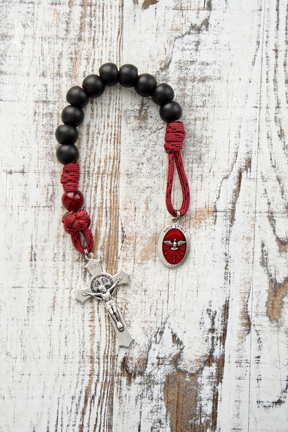 The Crimson Shield - Holy Spirit Confirmation 1 Decade Paracord Rosary: Durable 550 paracord rosary designed for boys or men preparing to receive the Sacrament of Confirmation, featuring dark maroon Our Father beads, matte black Hail Mary beads, a 2" St. Benedict crucifix, and a red enamel Holy Spirit devotional medal centerpiece.