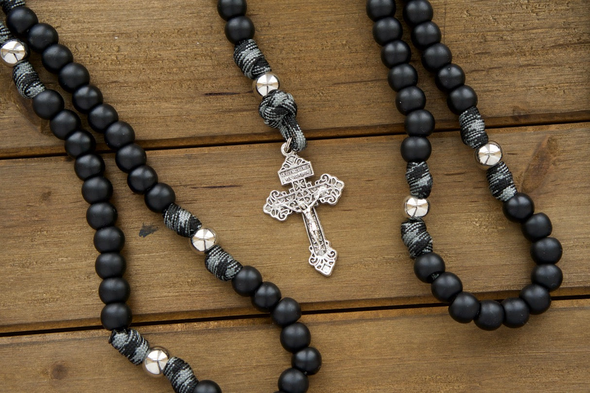 The Demon Destroyer - Black and Silver 5 Decade Paracord Rosary with durable paracord and powerful protection from silver crucifix and St. Benedict medal, perfect for men's spiritual journey against life's obstacles. Handmade by a Catholic family of 6, customizable in rope/bead color or crucifix/devotional medal size.