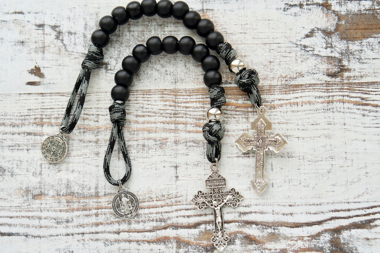 The Demon Destroyer - 1 Decade Paracord Rosary, featuring a sleek black and silver design, durable paracord, protective St. Benedict medal and silver crucifix, perfect for daily spiritual nourishment and conquer life's obstacles.