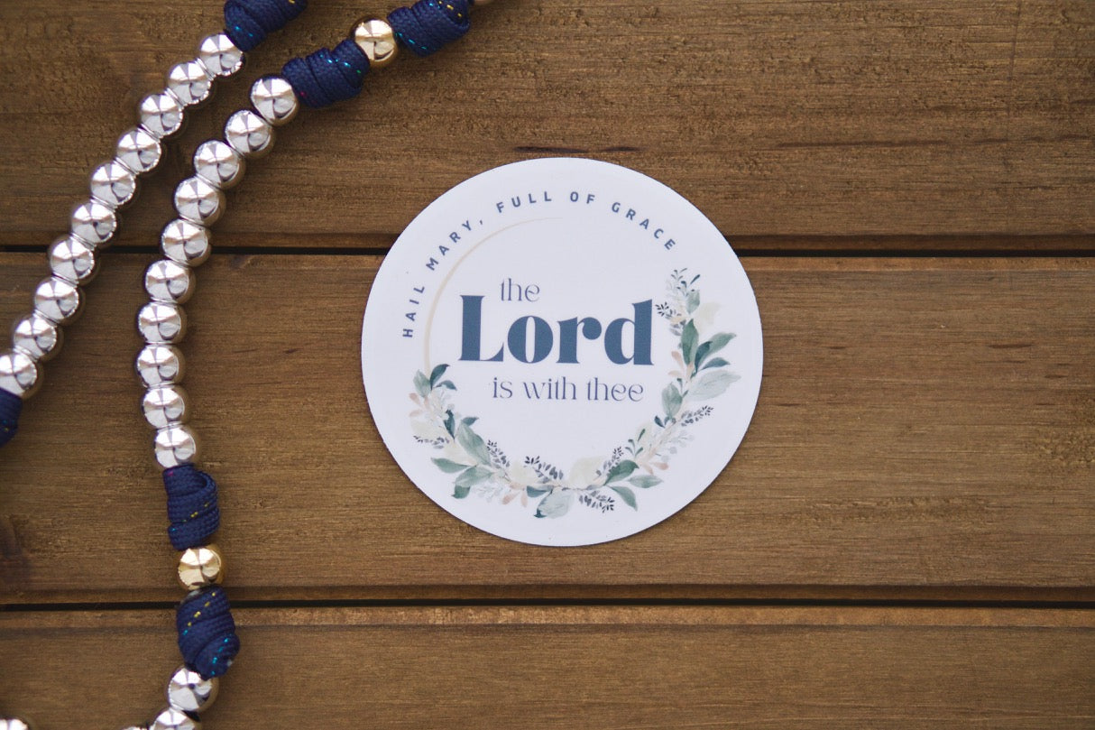Hail Mary, Full of Grace - Vinyl Sticker: Embark on your spiritual journey with this 3" x 3" Hail Mary prayer sticker inspired by Luke 1:28. Pair it with our unbreakable paracord rosary for a powerful combination in spreading the faith! Durable, premium, and removable without residue.