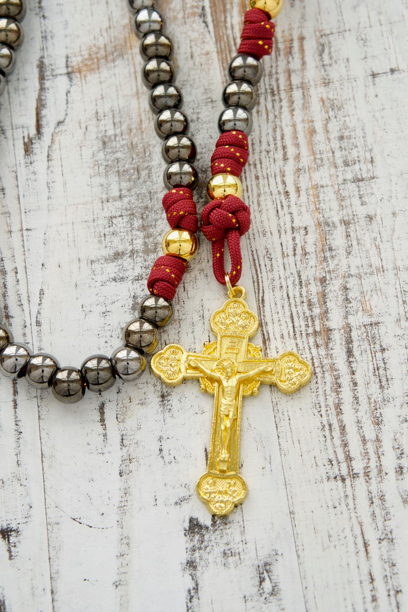 The Holy Family 5 Decade Paracord Rosary - Durable, Premium Catholic Gift for Prayer Warriors. Royal red, gold, and gunmetal design with a large 3" gold crucifix and powerful Holy Family/St. Joseph medal. Perfect for battlefield prayers and daily use.