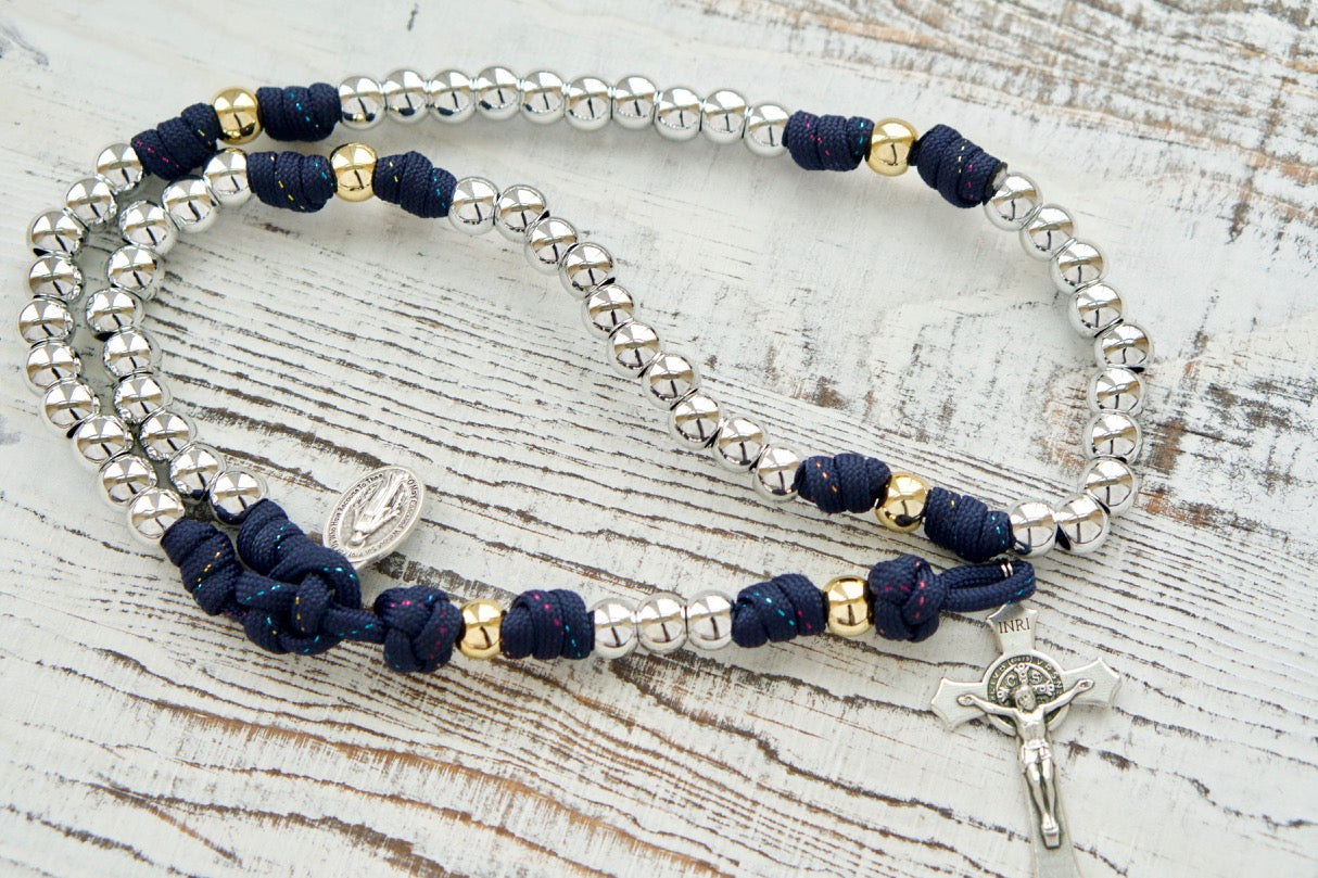 Dark Blue Paracord Rosary with Silver Hail Mary Beads and Gold Our Father Beads, featuring a 2" St. Benedict Crucifix and Miraculous Medal. Handmade by a small Catholic family for spiritual strength and devotion.