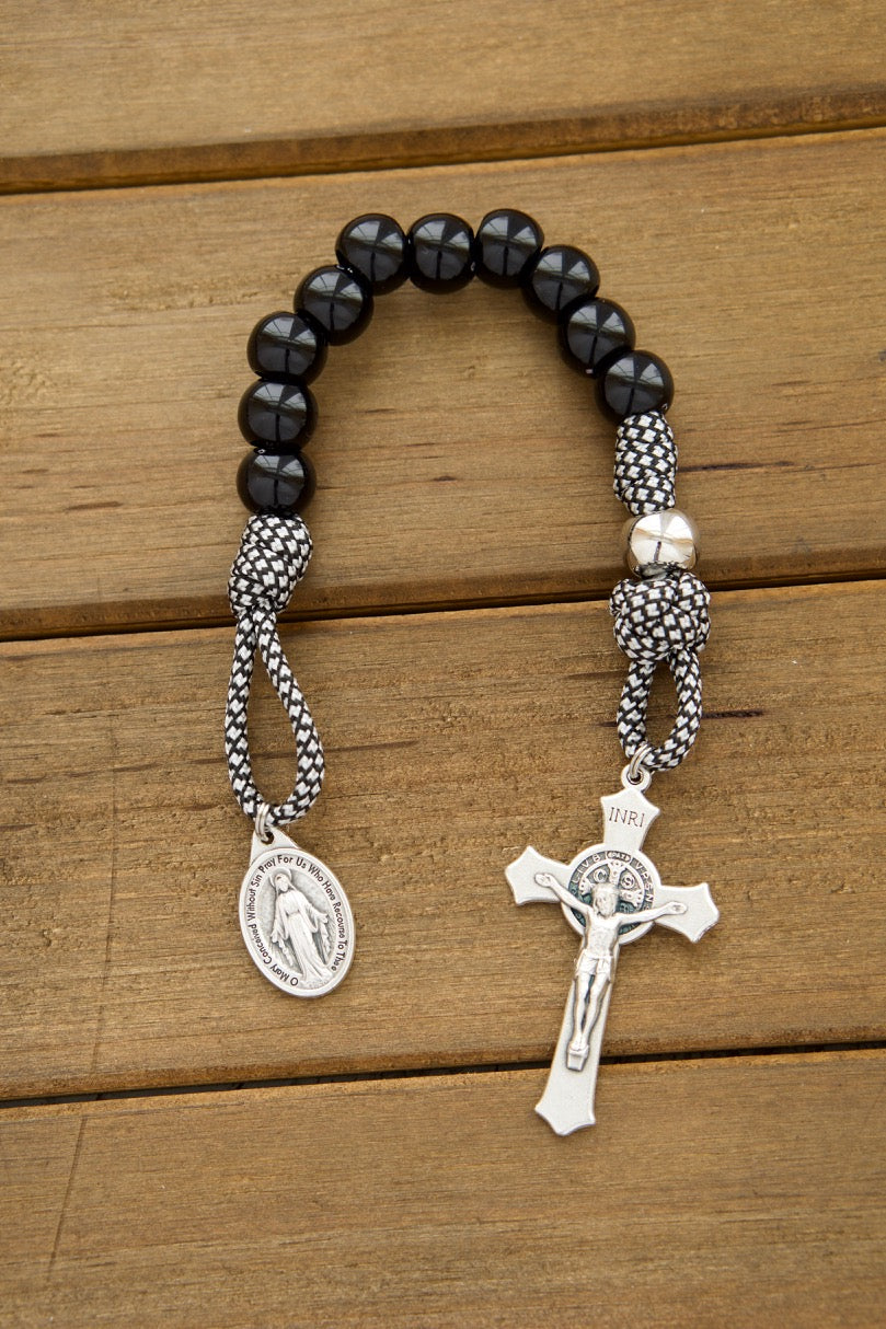 Two single decade paracord rosaries with black and white decades, St. Benedict crucifixes, and Miraculous Medals for a Catholic wedding gift set