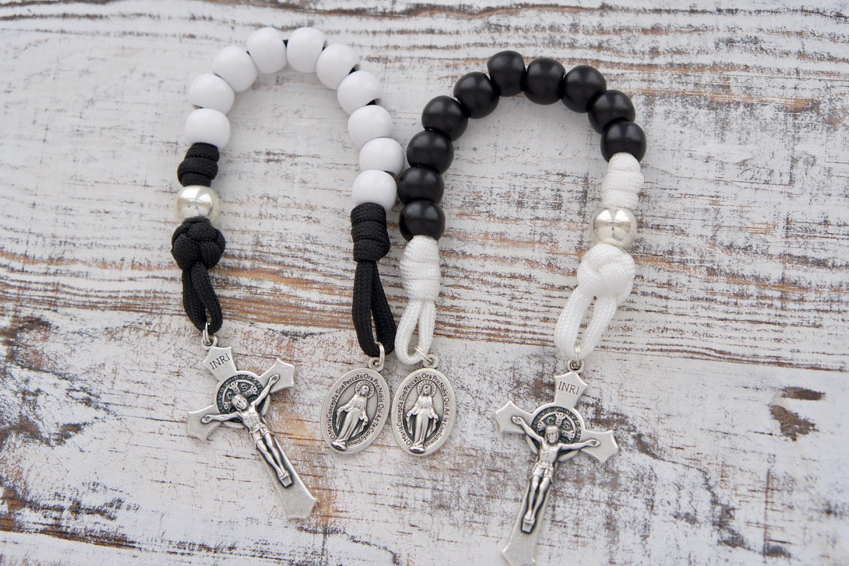 Celebrate your love with this beautiful Bride & Groom 1 Decade Rosary Pair, perfect for Catholic newlyweds or anniversary couples. Handmade by our devout Catholic family, these durable and unbreakable paracord rosaries feature a white and black design, Miraculous Medal, and St. Benedict Crucifix. A premium Catholic gift for your beloved on their special day!